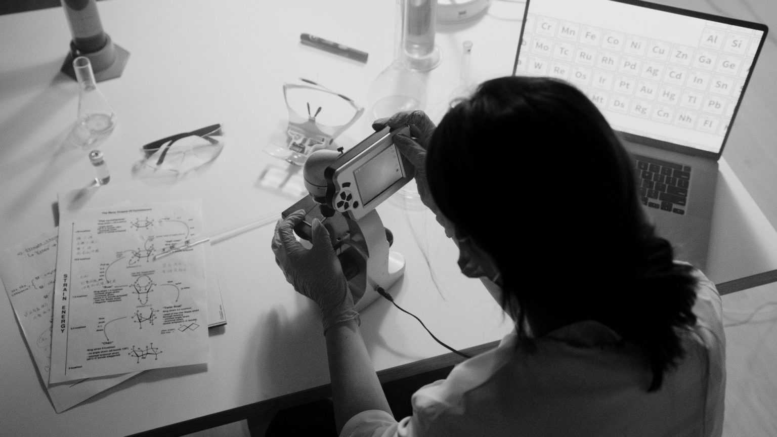 Pesquisador observa uma amostra ao microscópio em um laboratório.