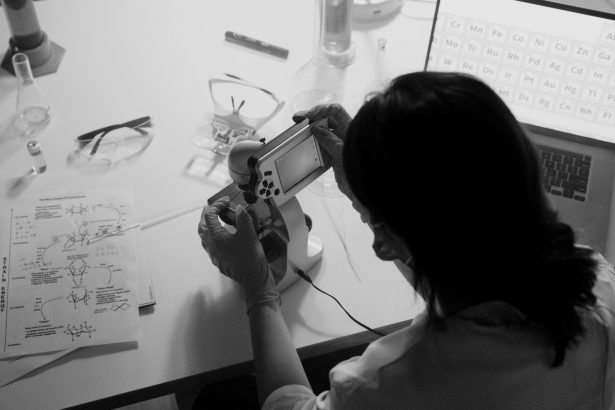 Pesquisador observa uma amostra ao microscópio em um laboratório.