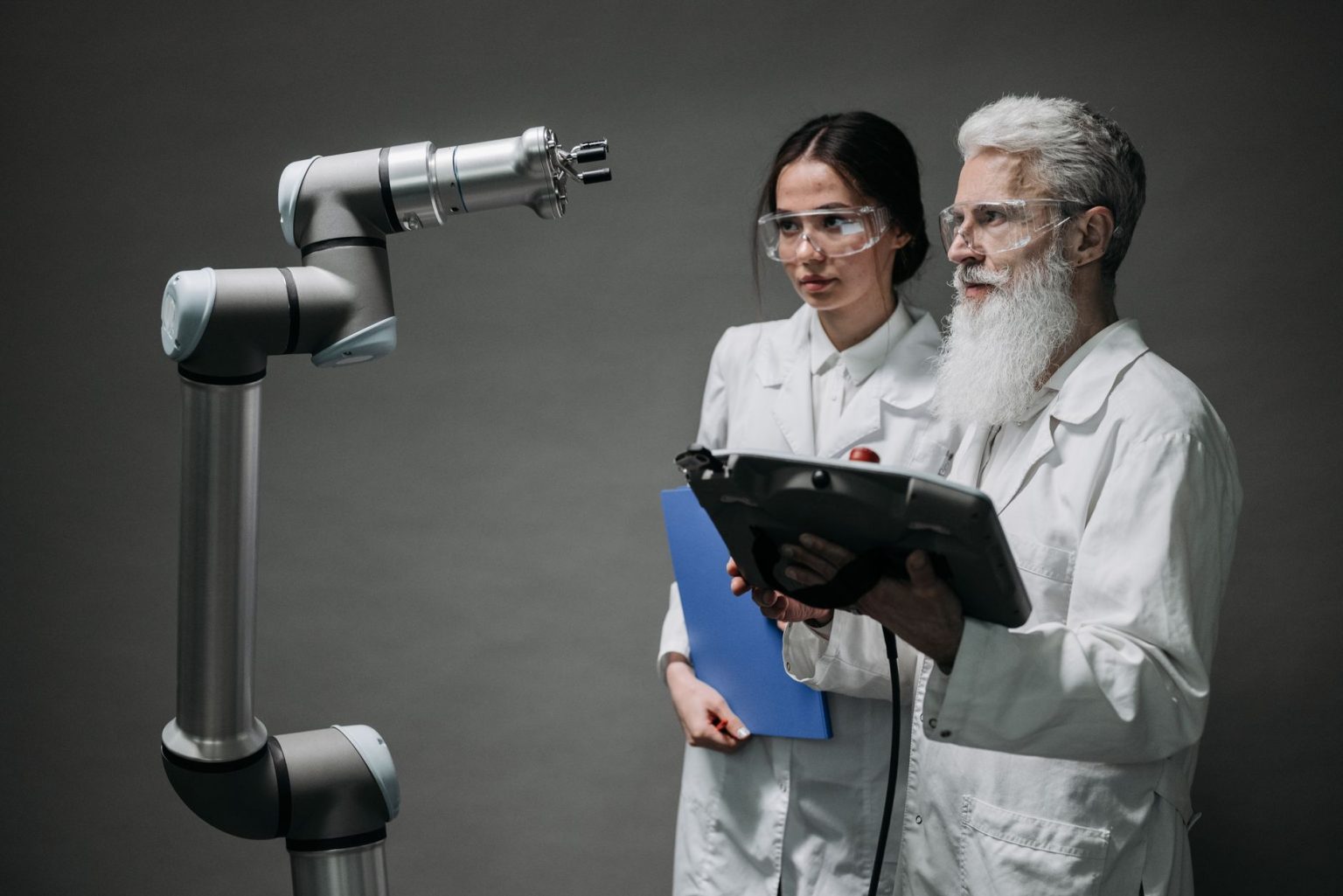 Pesquisadores examinam um braço robótico em um laboratório de tecnologia.